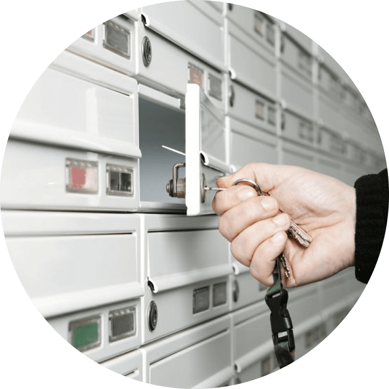 Hand with key opening safe deposit box