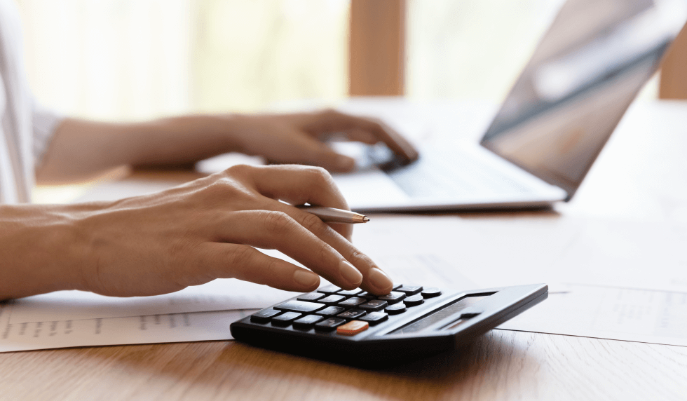 hand at desk with calculator