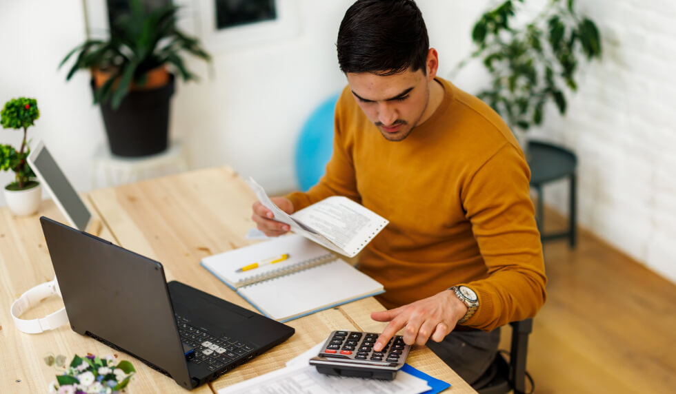 man with paperwork and calculator