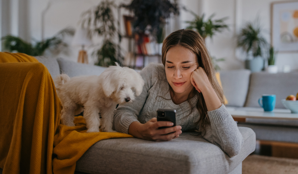 Girl looking at her phone with her dog