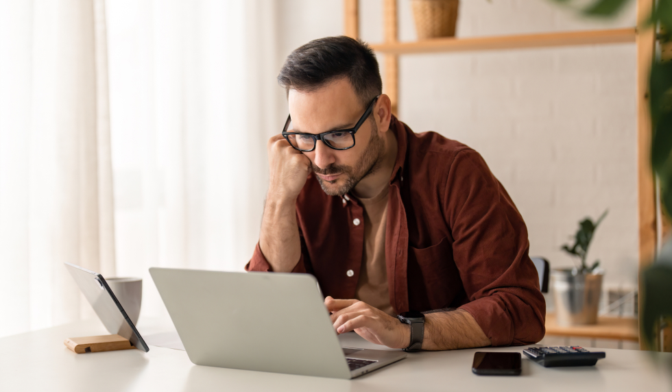 Man concerned while looking at his computer