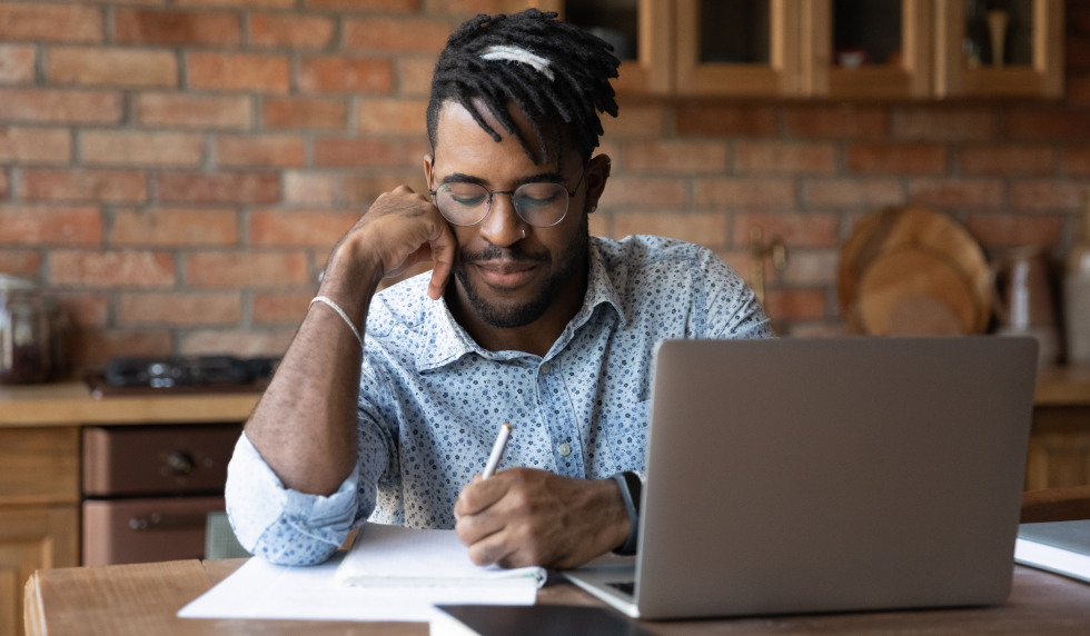 What To Do if You Are Scammed Man working at computer and writing something down