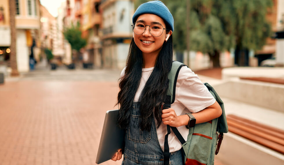 Student with backpack carrying laptop