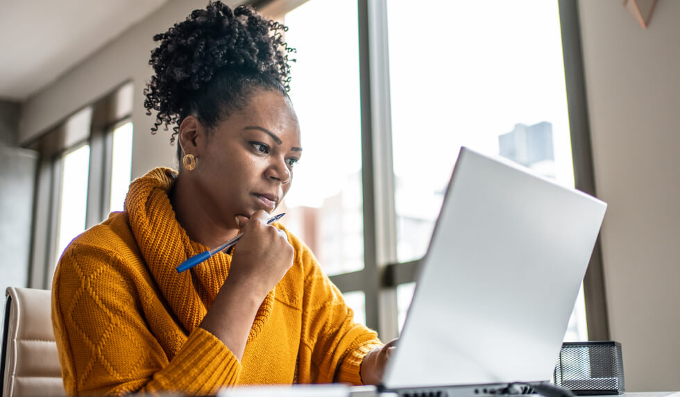 woman concerned while looking at computer