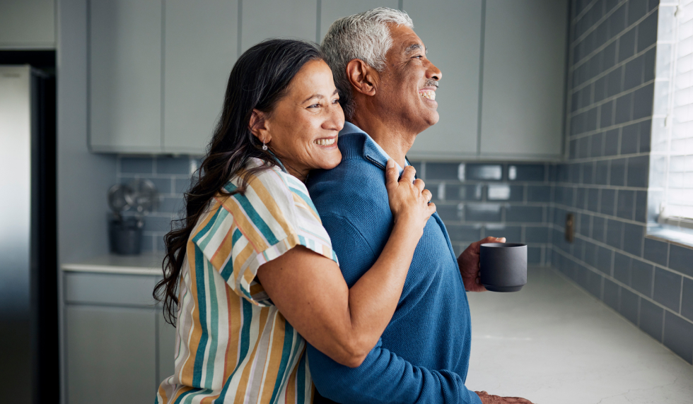 Smiling man and woman hugging in a kitchen