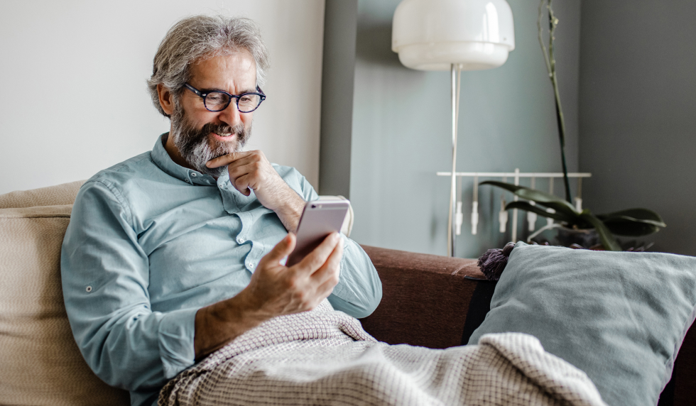 Man looking at phone on couch