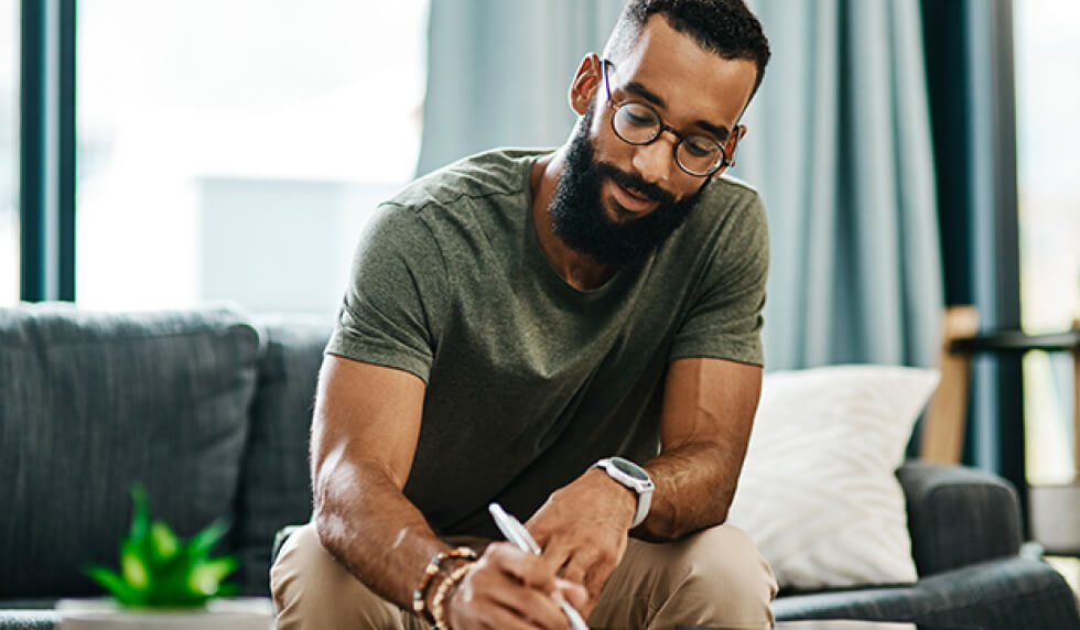 man signing documents in home