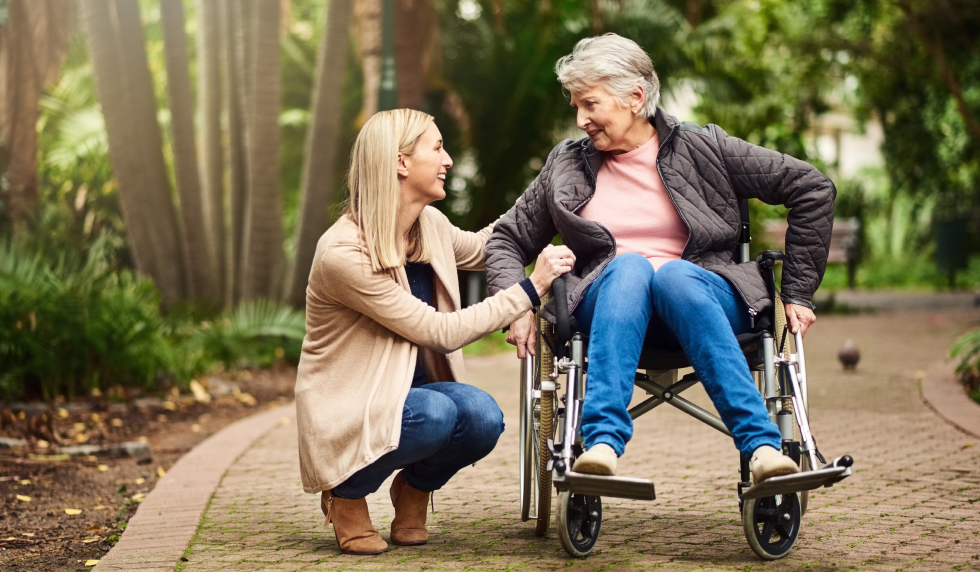 Elderly woman in wheelchair with caregiver