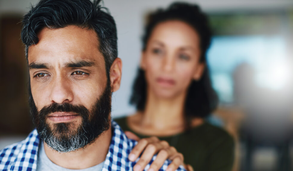 woman with hand on man's shoulder