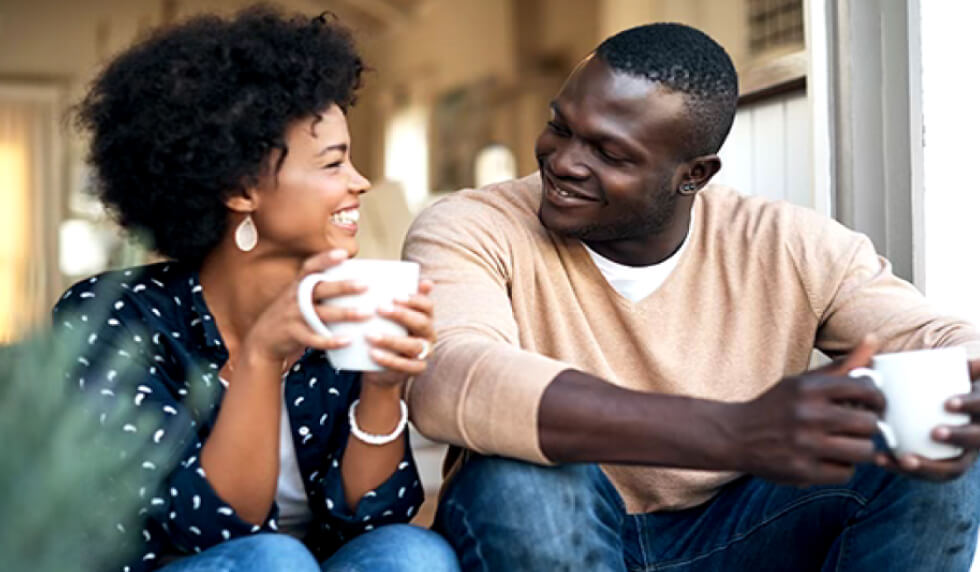 Couple sitting down outside house